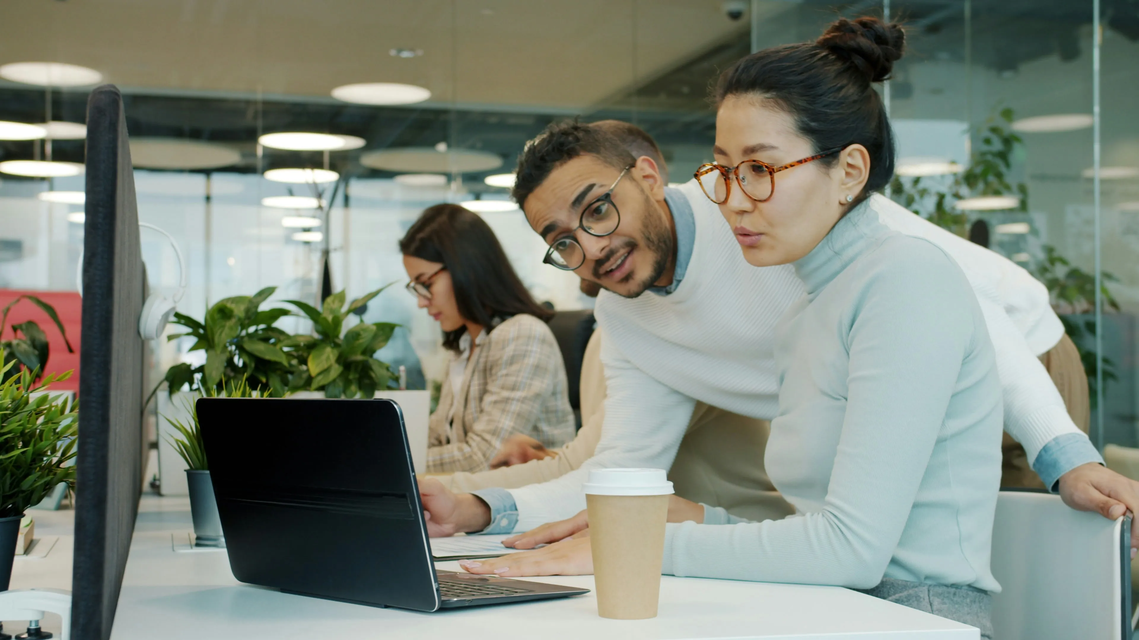 Deux collaborateurs d'une PME consultent un écran ensemble, l'environnement Microsoft 365 sécurisé en continu par YSY ONE
